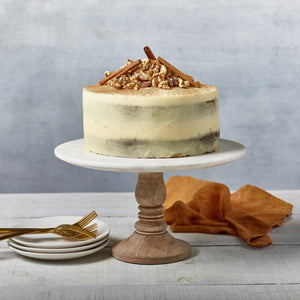 Carrot cake with cream cheese icing and a walnut and cinnamon decor.